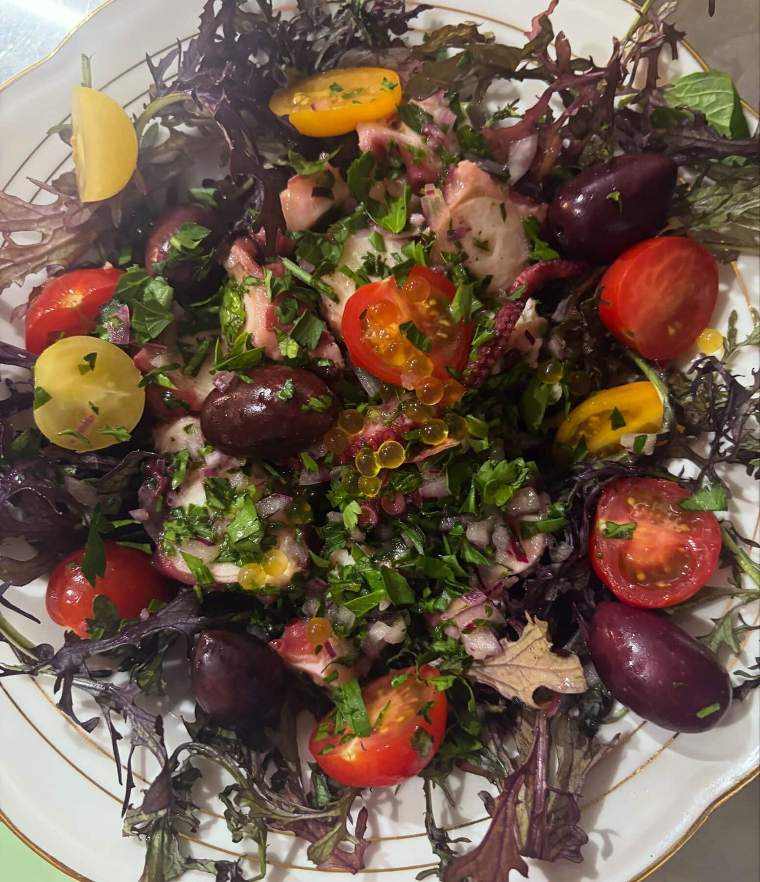 Salade de poulpe à la bastiaise : poulpe, tomates, olives noires et persil.