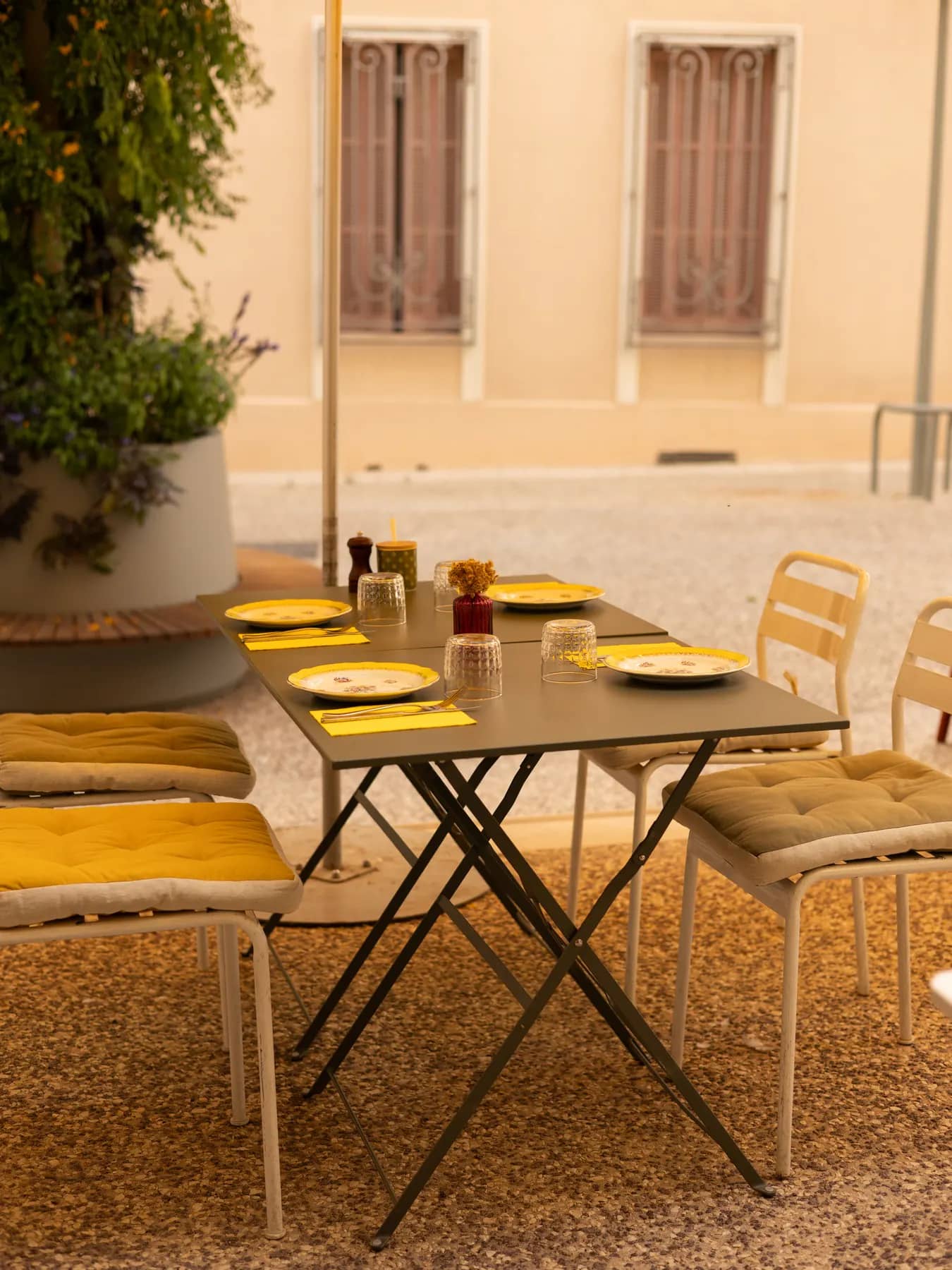 La terrasse du Bistrot Napoléon à Hyères : tables et chaises bistrot en métal, devanture ornée de plantes, prête à accueillir vos réservations.