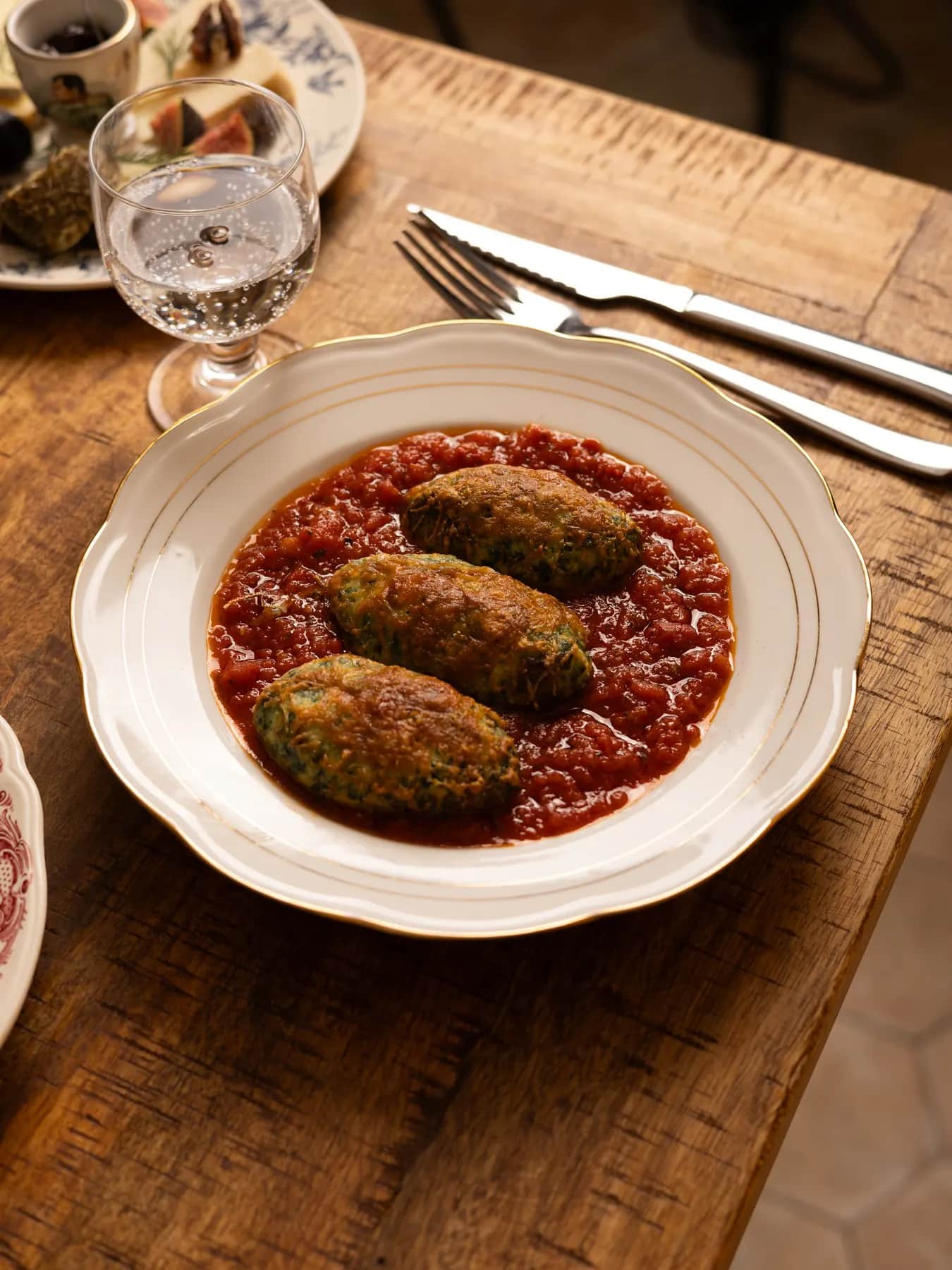 Storzapretti : quenelles de brocciu et de blette gratinées à la tomme de brebis, sur une sauce tomate aux herbes du maquis.