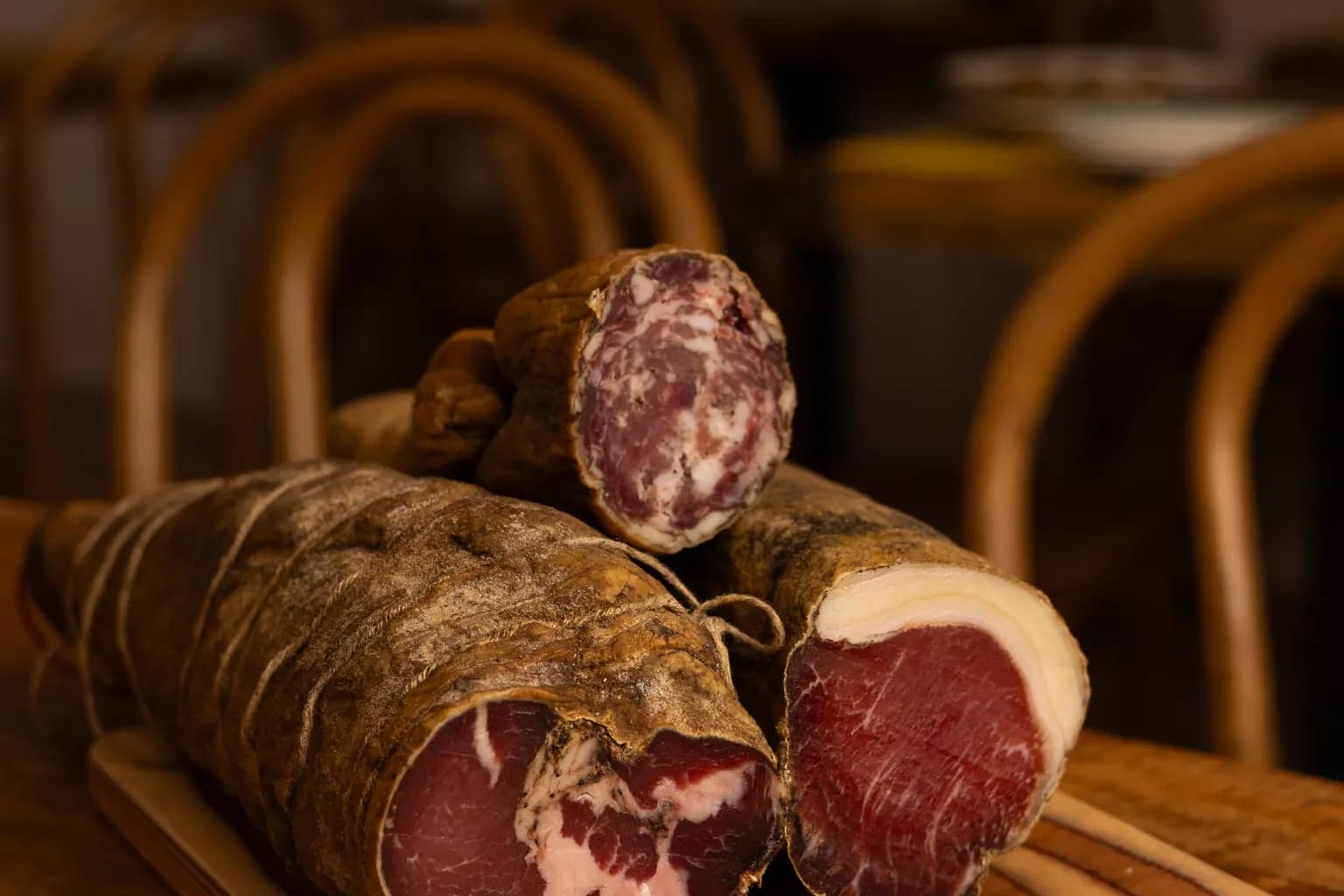 Coppa, lonzu et saucisson corses entiers, séchés sous leur peau, sur une planche du Bistrot Napoléon à Hyères.